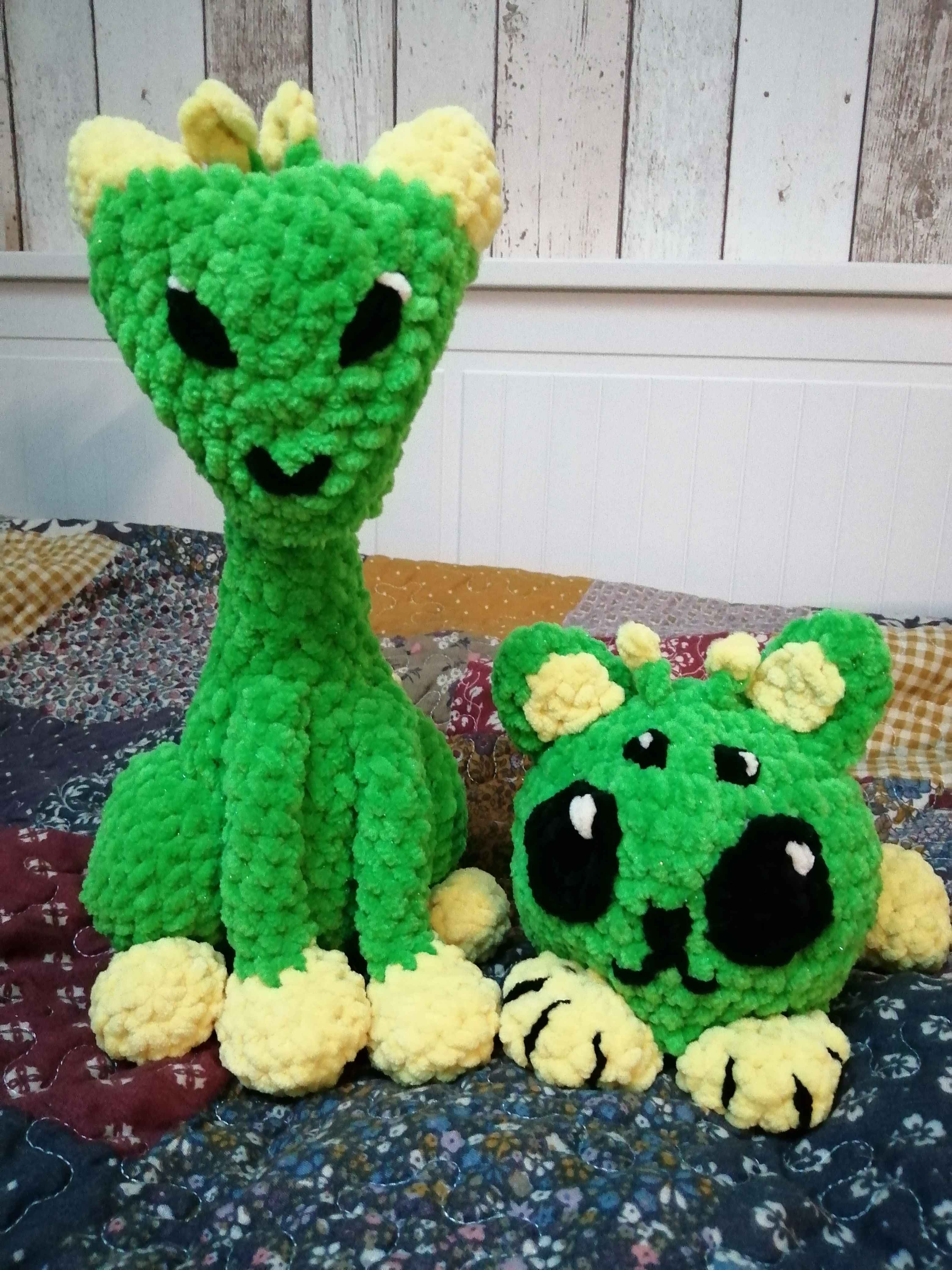 Picture of two crocheted green and yellow alien cats.