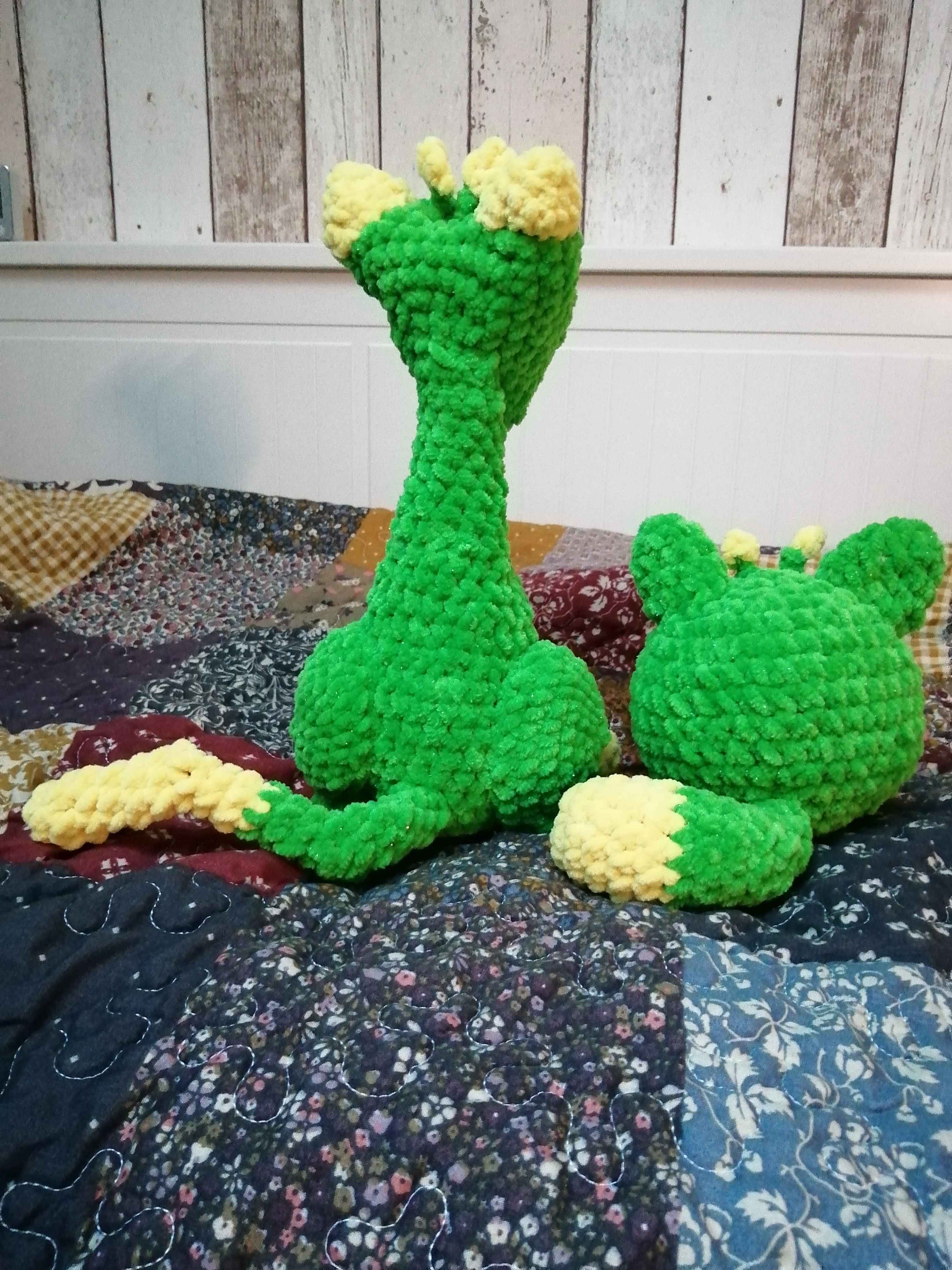 Picture of two crocheted green and yellow alien cats.